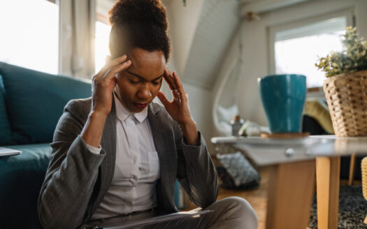 African American businesswoman having a headache and feeling tired while working at home.